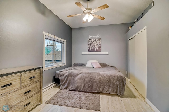 2814 26th Street Cir S, Moorhead, MN 56560 - bedroom with a baseboard heating unit, light wood-style flooring, a ceiling fan, and baseboards