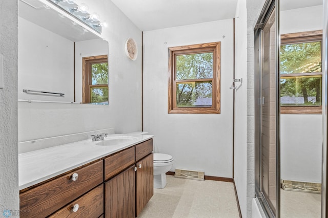 2207 16th St S, Fargo, ND 58103 - full bath featuring vanity, toilet, a shower with shower door, and baseboards