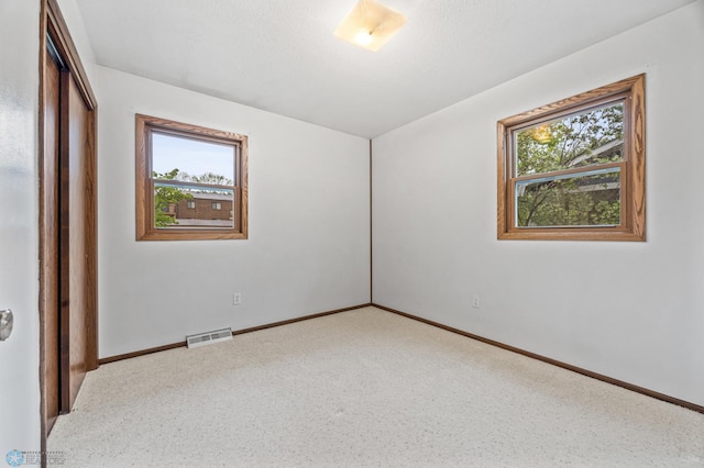 2207 16th St S, Fargo, ND 58103 - unfurnished bedroom with multiple windows, a closet, baseboards, and carpet flooring