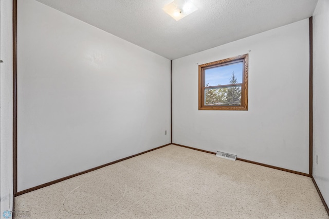 2207 16th St S, Fargo, ND 58103 - spare room featuring baseboards, a textured ceiling, and carpet floors