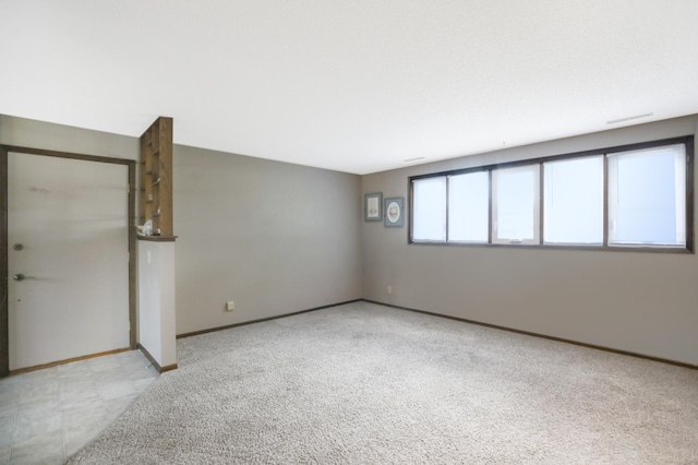 carpeted empty room featuring baseboards