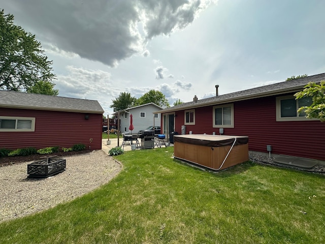 404 5th Ave NE, Kasson, MN 55944 - view of grassy yard featuring an outdoor fire pit, a hot tub, and a patio