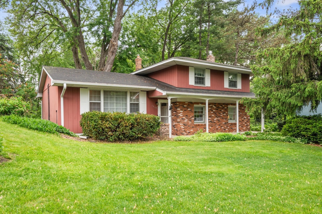 1134 Lealand Rd E, Maplewood, MN 55109 - view of front of home with a chimney and a front lawn