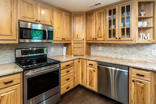 3010 Fairview Rd SW, Prior Lake, MN 55372 - kitchen featuring appliances with stainless steel finishes, light stone counters, tasteful backsplash, glass insert cabinets, and dark wood finished floors