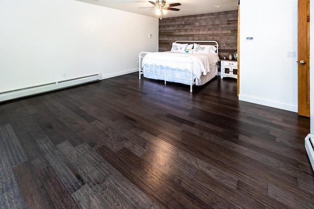 3010 Fairview Rd SW, Prior Lake, MN 55372 - bedroom featuring wooden walls, dark wood-style flooring, baseboards, a ceiling fan, and a baseboard radiator