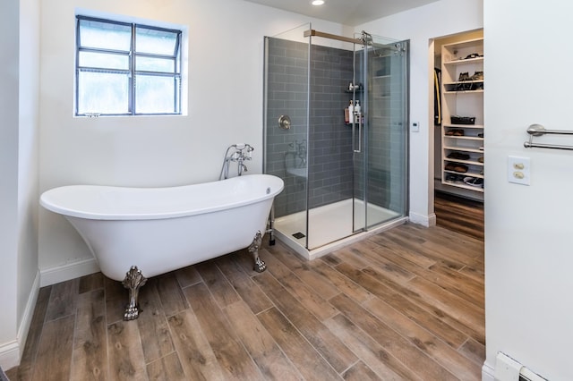 3010 Fairview Rd SW, Prior Lake, MN 55372 - full bathroom with a shower stall, wood finished floors, baseboard heating, a spacious closet, and a freestanding bath