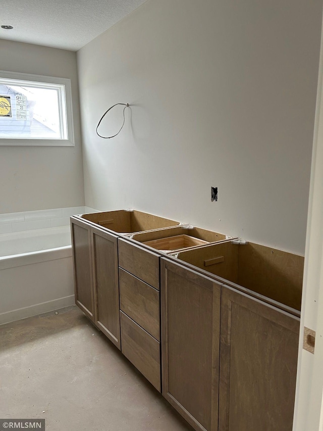 10101 Blackmoor Rd, Woodbury, MN 55129 - full bathroom featuring concrete floors, a bath, and a textured ceiling