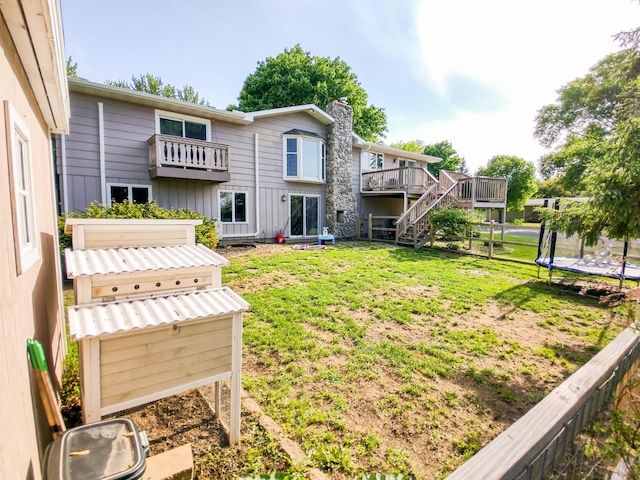 620 Maple St, Dassel, MN 55325 - rear view of house featuring a trampoline, stairs, a yard, a chimney, and board and batten siding