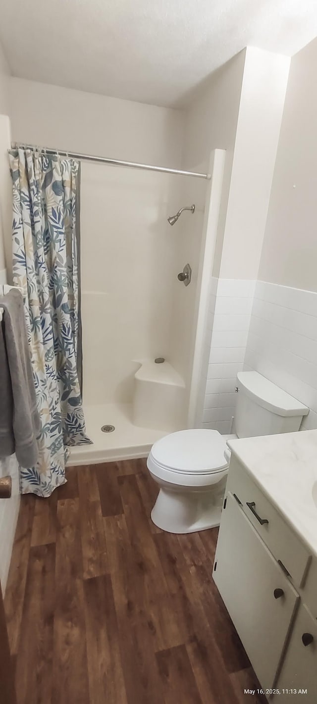 620 Maple St, Dassel, MN 55325 - full bath featuring vanity, toilet, curtained shower, wood finished floors, and a wainscoted wall
