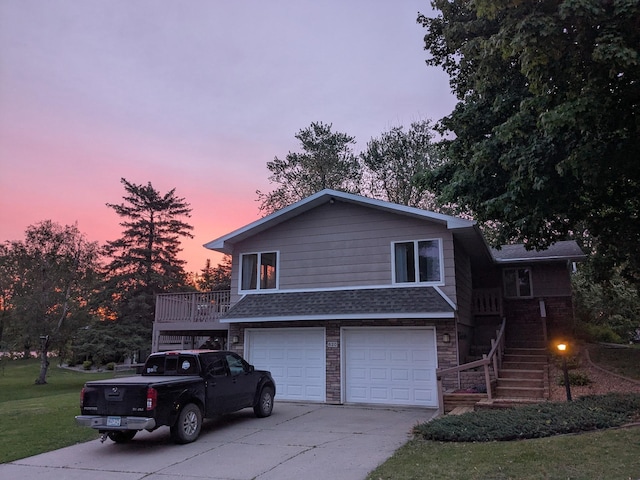 620 Maple St, Dassel, MN 55325 - split level home featuring concrete driveway, stairway, a garage, a shingled roof, and a lawn