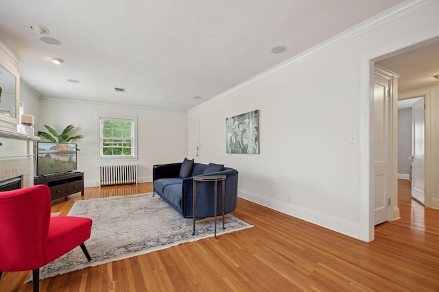 1785 Dupont Ave S, Minneapolis, MN 55403 - living room with radiator, wood finished floors, baseboards, crown molding, and a fireplace
