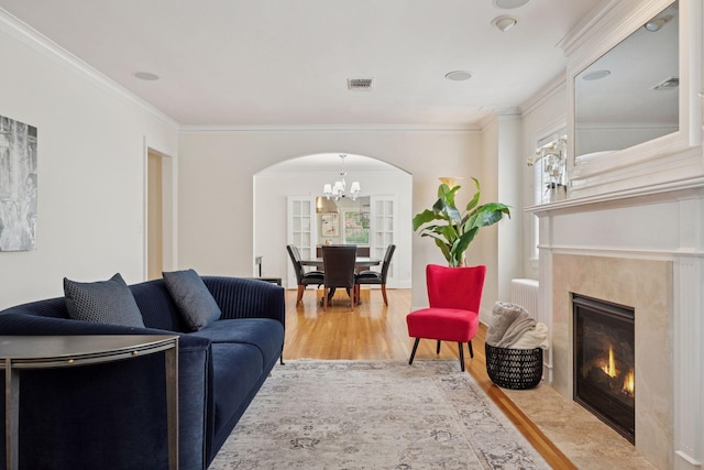 1785 Dupont Ave S, Minneapolis, MN 55403 - living area featuring a chandelier, arched walkways, wood finished floors, crown molding, and a premium fireplace