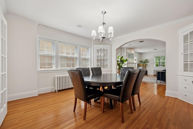 1785 Dupont Ave S, Minneapolis, MN 55403 - dining area featuring radiator heating unit, a chandelier, arched walkways, light wood-style flooring, and ornamental molding