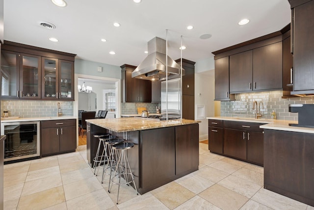 1785 Dupont Ave S, Minneapolis, MN 55403 - kitchen with wine cooler, island range hood, decorative backsplash, stainless steel appliances, and recessed lighting