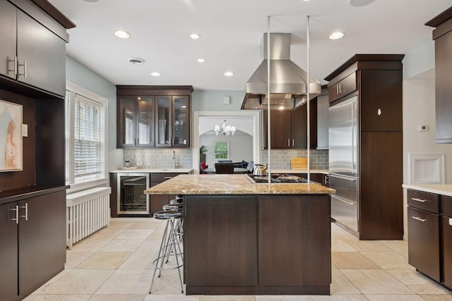 1785 Dupont Ave S, Minneapolis, MN 55403 - kitchen with beverage cooler, island range hood, tasteful backsplash, dark brown cabinetry, and recessed lighting