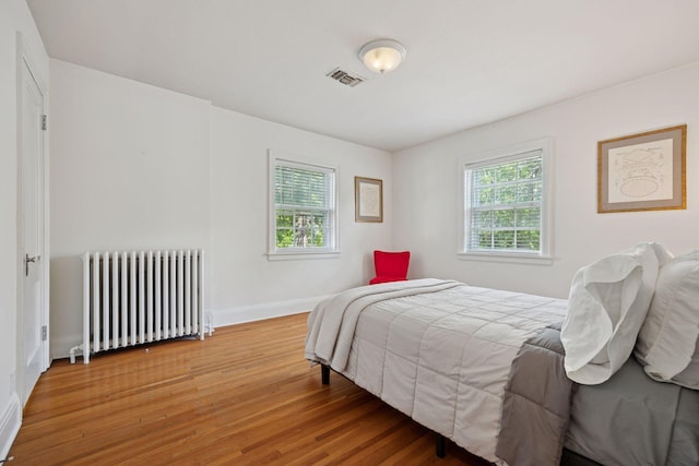 1785 Dupont Ave S, Minneapolis, MN 55403 - bedroom featuring radiator heating unit, light wood-style floors, and baseboards