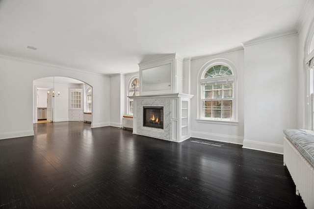 1785 Dupont Ave S, Minneapolis, MN 55403 - unfurnished living room with ornamental molding, a high end fireplace, dark wood-type flooring, arched walkways, and baseboards