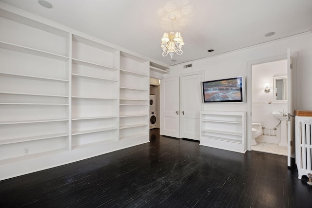 1785 Dupont Ave S, Minneapolis, MN 55403 - unfurnished living room with stacked washer / dryer, a chandelier, and dark wood-style flooring