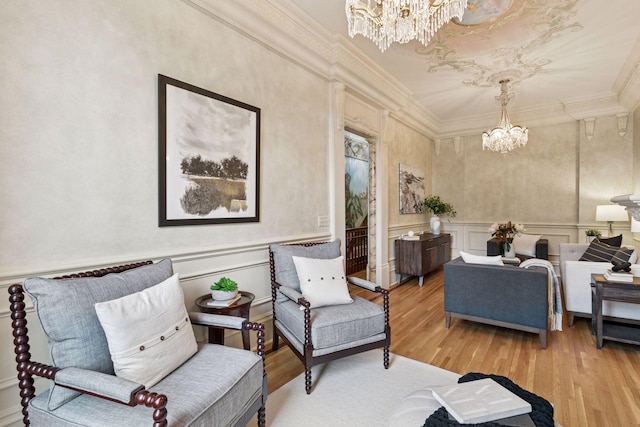 8 Grove St Unit 8B, Minneapolis, MN 55401 - sitting room featuring a chandelier, a decorative wall, light wood-style floors, ornamental molding, and wainscoting