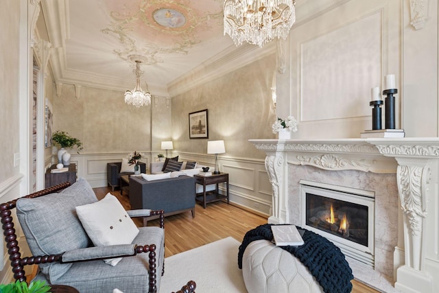 8 Grove St Unit 8B, Minneapolis, MN 55401 - living room featuring a chandelier, a decorative wall, wood finished floors, ornamental molding, and a high end fireplace