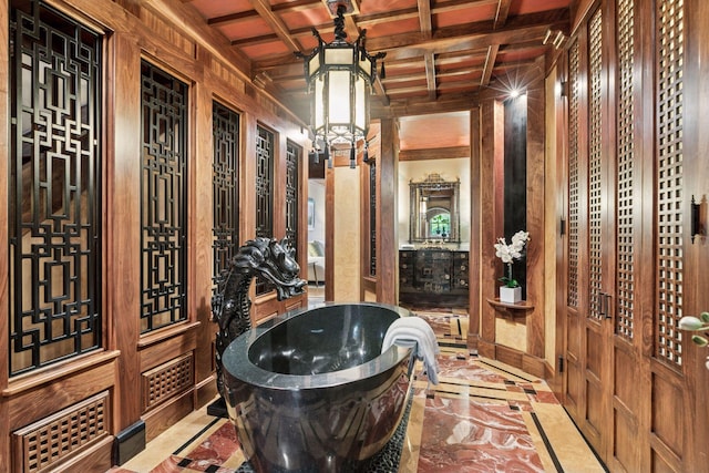 8 Grove St Unit 8B, Minneapolis, MN 55401 - bathroom featuring inlaid floor details, a soaking tub, wooden walls, and a chandelier
