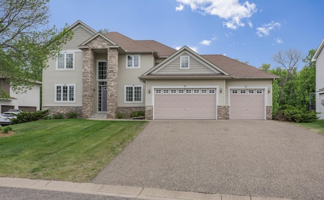 10543 Noble Cir N, Brooklyn Park, MN 55443 - view of front of house with a front yard, asphalt driveway, an attached garage, and brick siding