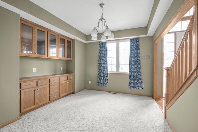 10543 Noble Cir N, Brooklyn Park, MN 55443 - unfurnished dining area featuring light carpet, stairway, a chandelier, and baseboards