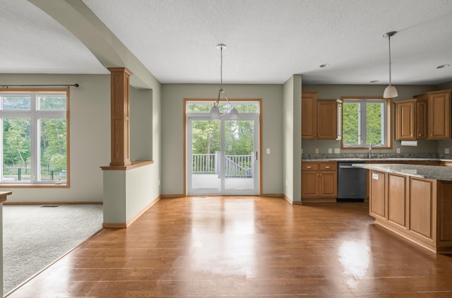 10543 Noble Cir N, Brooklyn Park, MN 55443 - kitchen with dishwashing machine, wood finished floors, brown cabinets, baseboards, and a textured ceiling