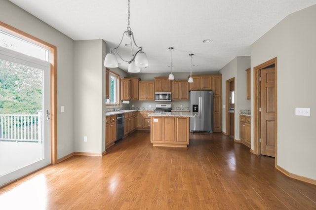 10543 Noble Cir N, Brooklyn Park, MN 55443 - kitchen with stainless steel appliances, a sink, wood finished floors, a center island, and pendant lighting