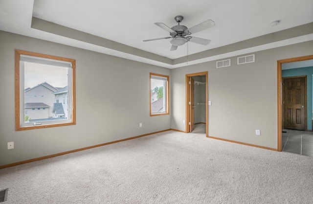 10543 Noble Cir N, Brooklyn Park, MN 55443 - unfurnished bedroom featuring baseboards, light colored carpet, a raised ceiling, and a spacious closet