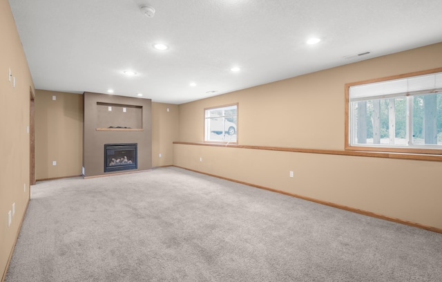 10543 Noble Cir N, Brooklyn Park, MN 55443 - unfurnished living room featuring baseboards, carpet, a glass covered fireplace, healthy amount of natural light, and recessed lighting