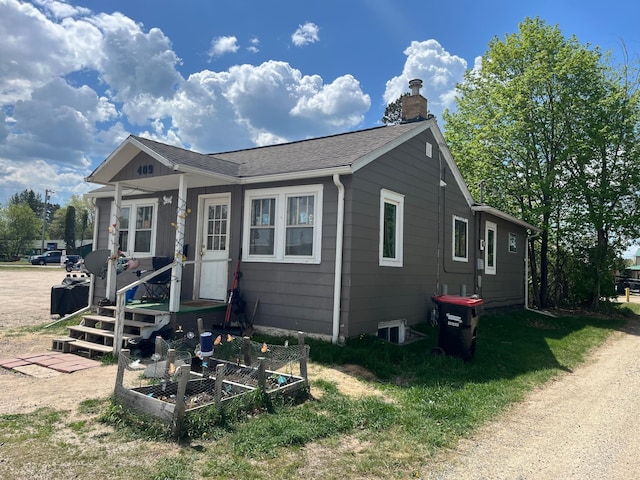 409 14th Ave, Grand Rapids, MN 55744 - bungalow featuring a chimney, roof with shingles, and a vegetable garden