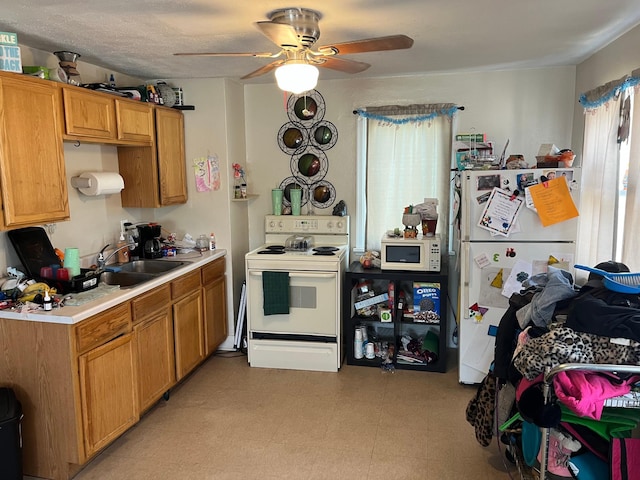 409 14th Ave, Grand Rapids, MN 55744 - kitchen with white appliances, a ceiling fan, a sink, light countertops, and light flooring