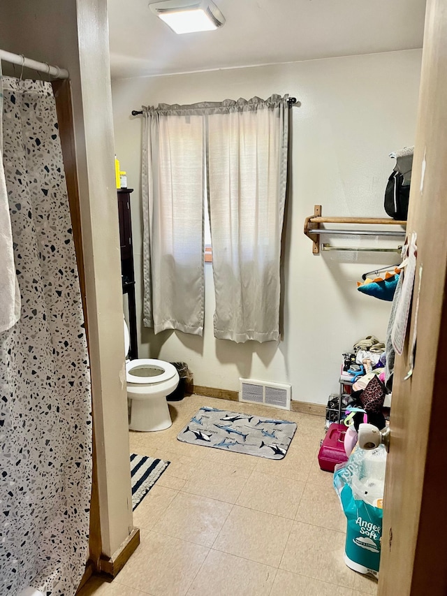 409 14th Ave, Grand Rapids, MN 55744 - bathroom featuring toilet, baseboards, a shower with curtain, and tile patterned flooring