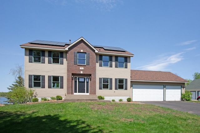 761 Country Lakes Dr, Lino Lakes, MN 55014 - view of front of home with driveway, a garage, a front lawn, and solar panels