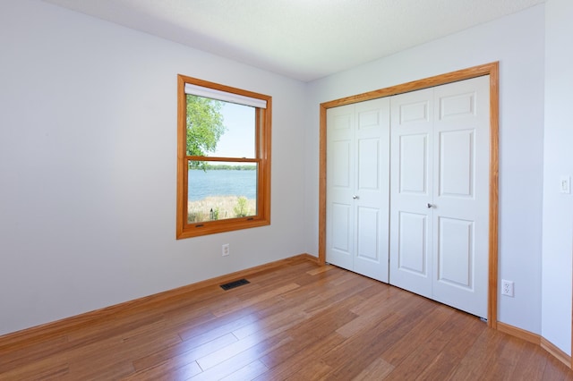 761 Country Lakes Dr, Lino Lakes, MN 55014 - unfurnished bedroom with light wood-style floors, a closet, and baseboards