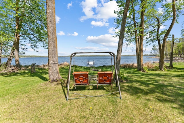 view of home's community with a water view and a lawn