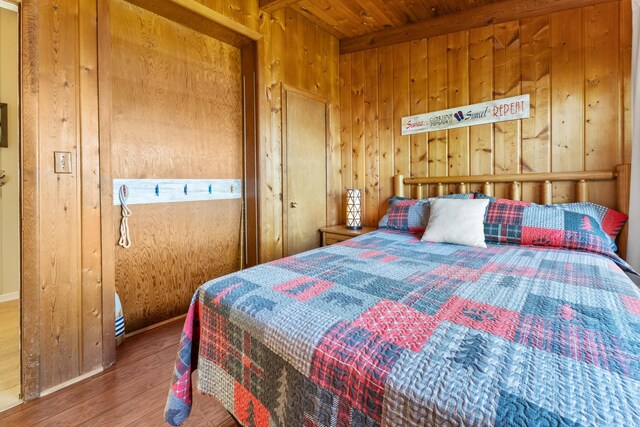 bedroom featuring wood finished floors, wooden walls, and wooden ceiling
