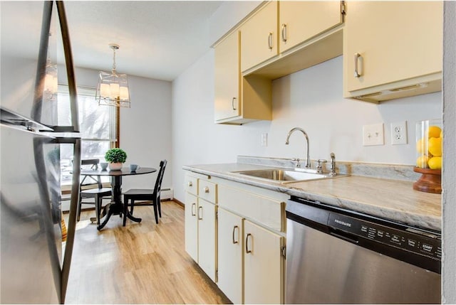 709 11th Ave S Unit 5, Hopkins, MN 55343 - kitchen featuring stainless steel dishwasher, a sink, light wood finished floors, a chandelier, and decorative light fixtures