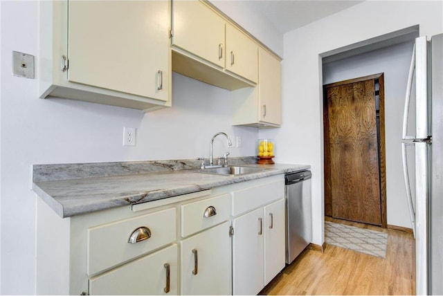 709 11th Ave S Unit 5, Hopkins, MN 55343 - kitchen featuring stainless steel dishwasher, a sink, light countertops, freestanding refrigerator, and light wood-type flooring
