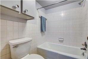 709 11th Ave S Unit 5, Hopkins, MN 55343 - bathroom featuring toilet, tile walls, and shower / washtub combination