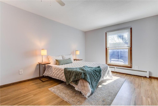 709 11th Ave S Unit 5, Hopkins, MN 55343 - bedroom featuring a baseboard radiator, wood finished floors, and baseboards