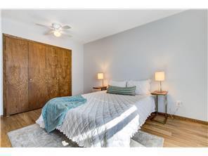 709 11th Ave S Unit 5, Hopkins, MN 55343 - bedroom with wood finished floors, baseboards, a closet, and a ceiling fan
