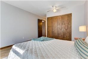 709 11th Ave S Unit 5, Hopkins, MN 55343 - bedroom with a closet, wood finished floors, baseboards, and ceiling fan