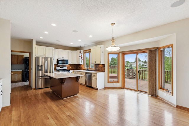3613 Clare Downs Path, Rosemount, MN 55068 - kitchen featuring stainless steel appliances, tasteful backsplash, light wood-type flooring, a sink, and a center island