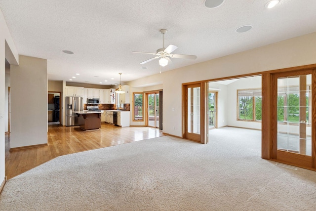 3613 Clare Downs Path, Rosemount, MN 55068 - unfurnished living room featuring baseboards, a textured ceiling, ceiling fan, light colored carpet, and recessed lighting