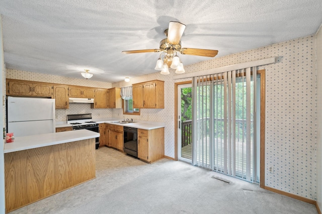 kitchen featuring range with gas cooktop, freestanding refrigerator, dishwasher, under cabinet range hood, and wallpapered walls