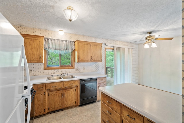 kitchen featuring black dishwasher, a sink, freestanding refrigerator, wallpapered walls, and light countertops