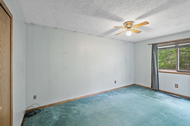 spare room featuring carpet flooring, a ceiling fan, a textured ceiling, and baseboards