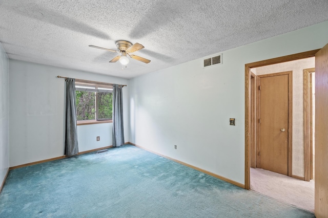 spare room with carpet flooring, ceiling fan, baseboards, and a textured ceiling
